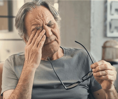  Vanhempi mies hieroo silmiään ja näyttää väsyneeltä